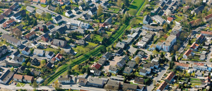 Der Heerener Mühlbach verläuft als Korridor mitten durch ein Kamener Wohngebiet, ehemals begradigt und eng gefasst im Betonsohlschalenbett.