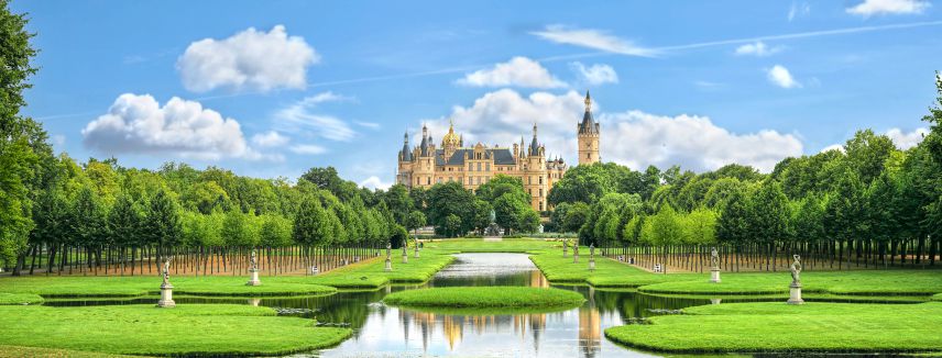 Das Schloss Schwerin (lizenziertes Stockfoto von Adobe) Foto vom Schloss Schwerin mit Garten im Vordergrund
