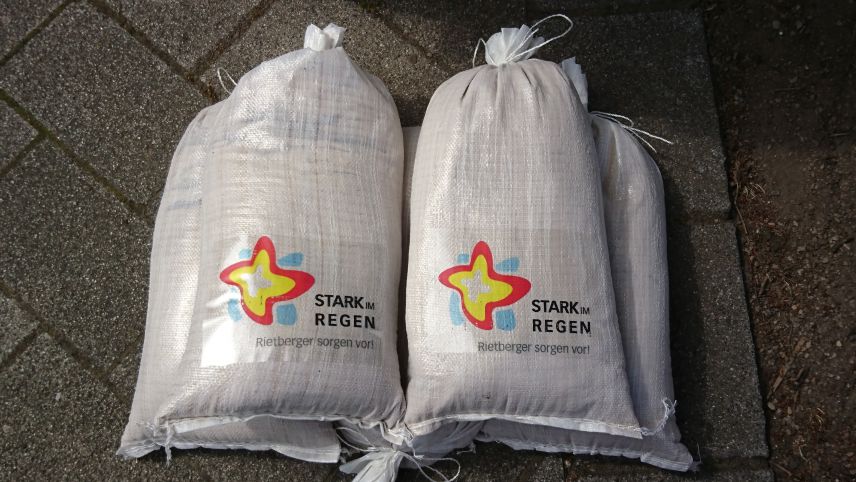 Foto von Sandsäcken mit aufgeklebten Projektlogo für den Hochwasserschutz