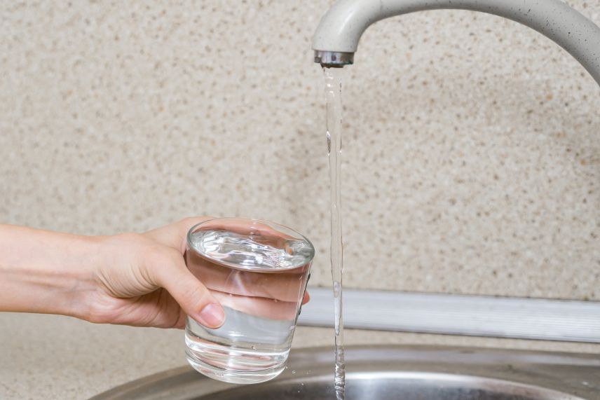 Ein laufender Wasserspender, der zum Füllen eines Glases genutzt wird
