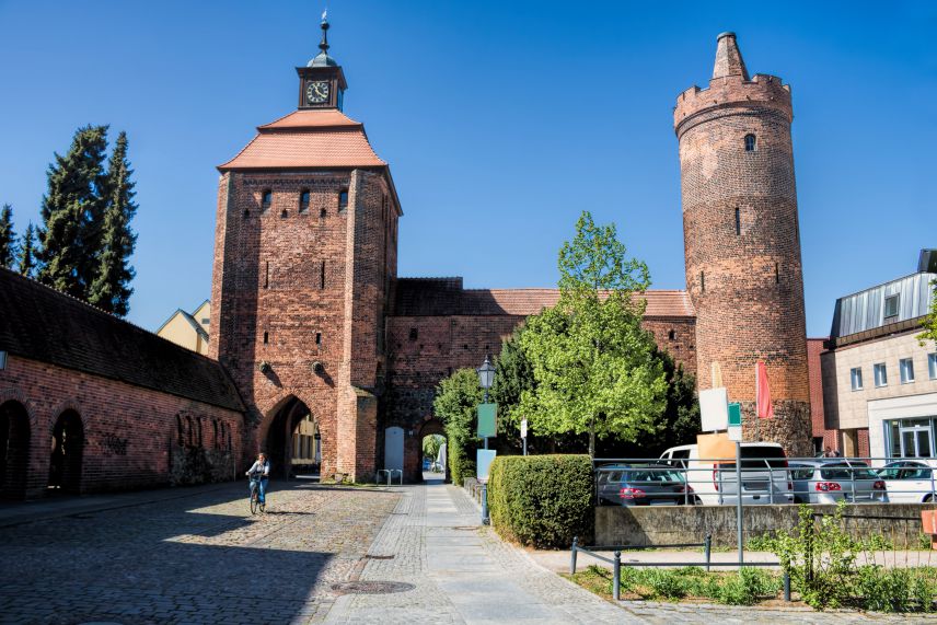 Mittelalterliche Stadtmauer in Bernau. Quelle: Adobe Stock 306415518 Großes Backstein Tor und Turm neben einer mittelalterlichen Stadtmauer.