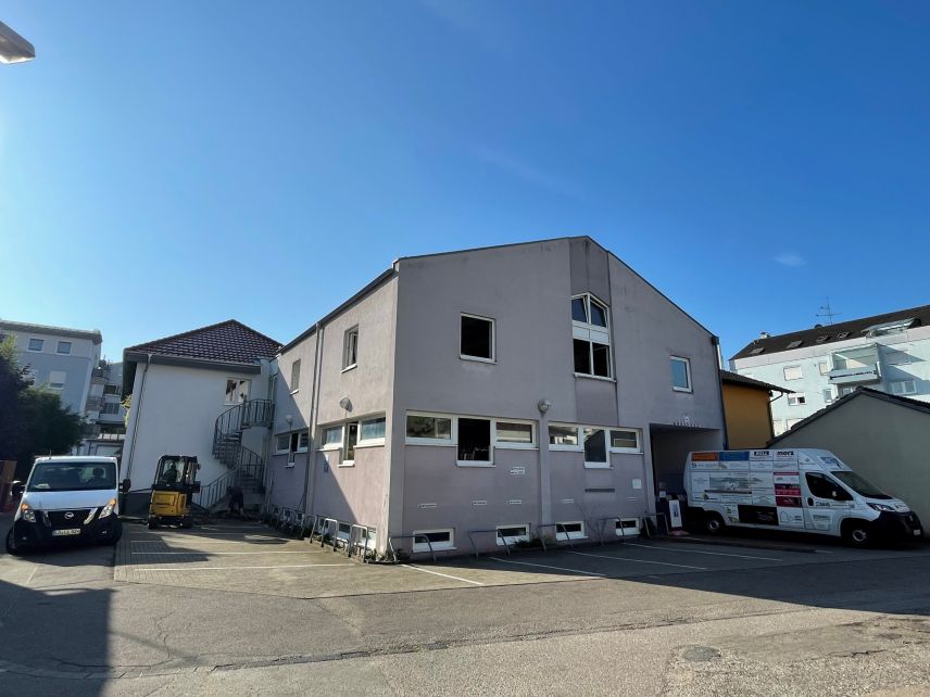 Zu sehen ein versiegelter Parkplatz vor einem Haus.